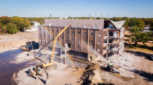 Photo showing an excavator and dust suppression in action at the former Mercy General Hospital Site.