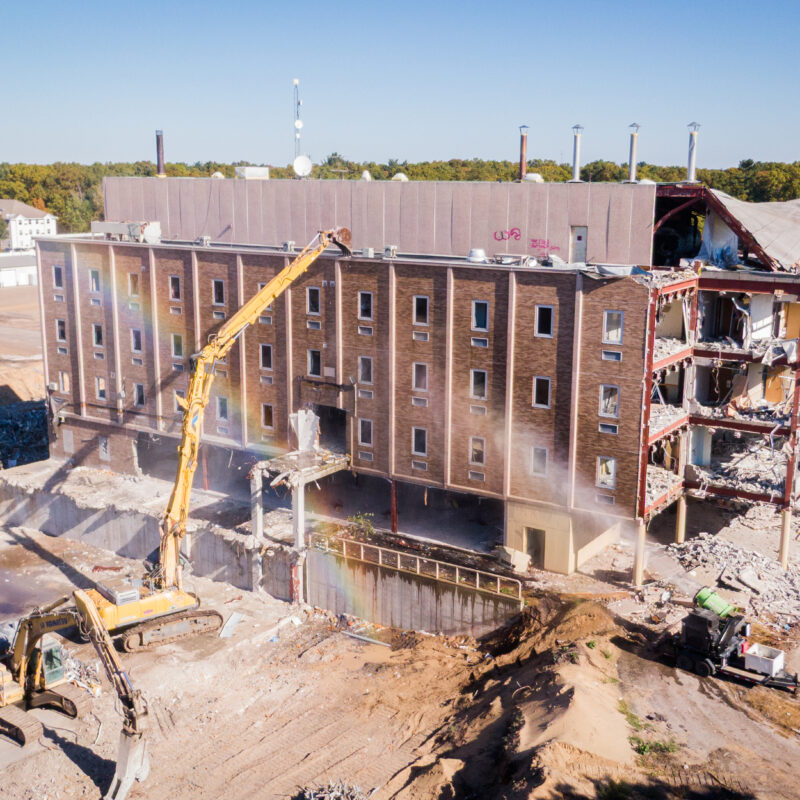 Photo showing an excavator and dust suppression in action at the former Mercy General Hospital Site.